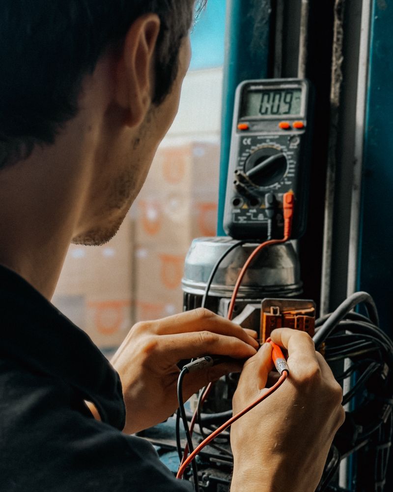 Elektriker misst mit einem Multimeter an einer Anschlussklemme.